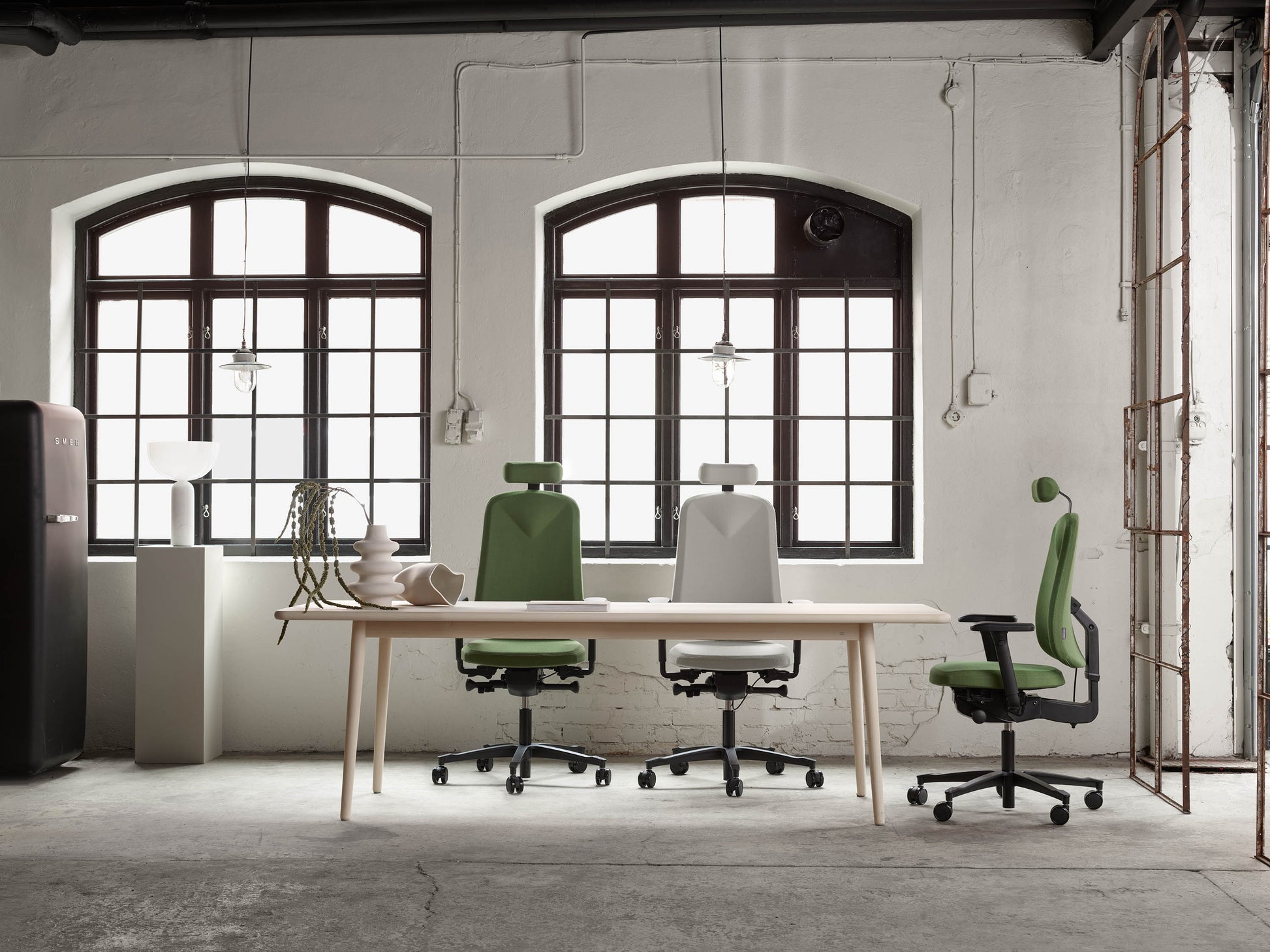 Kontorstol Höganäs +380 i svart med nackstöd, backup och armstöd i modernt arbetsrum med stora fönster.