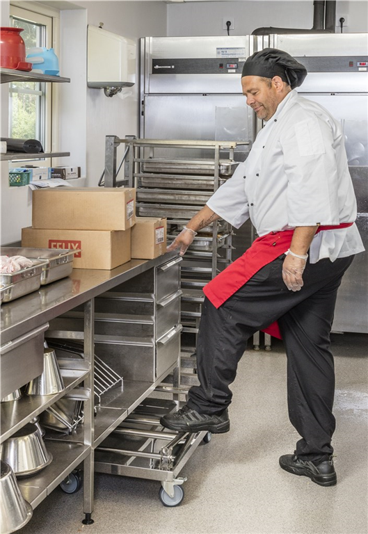 Rostfri plattformsvagn 830x530x940mm 100kg i köksmiljö med fällbart handtag och fyra länkhjul för enklare transporter.
