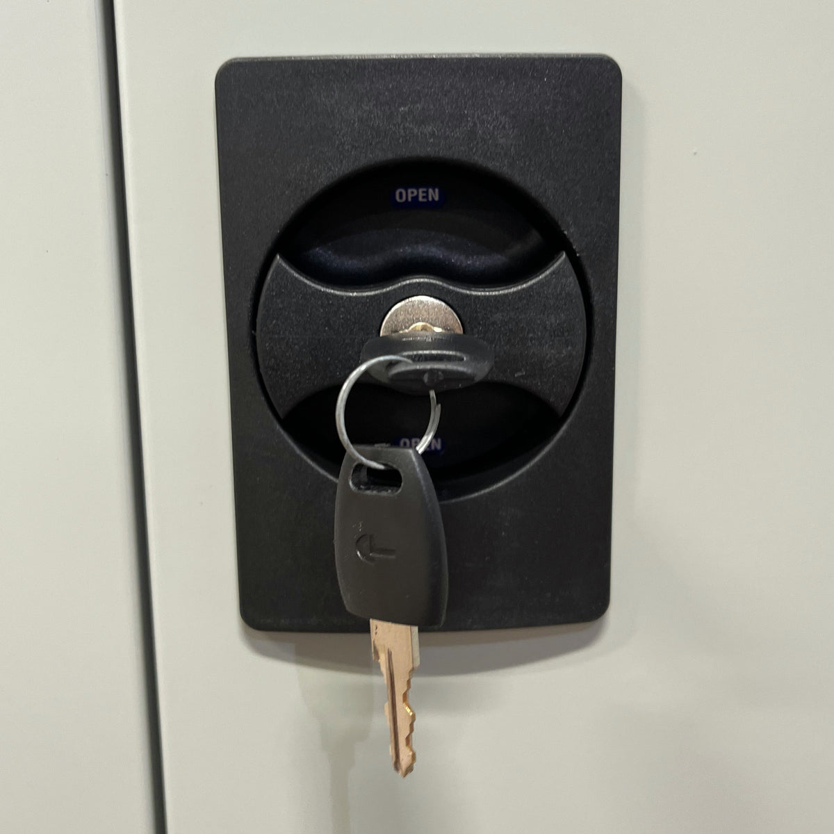 Vridhandtag med cylinderlås och nyckel på kemikalieskåpets dörr